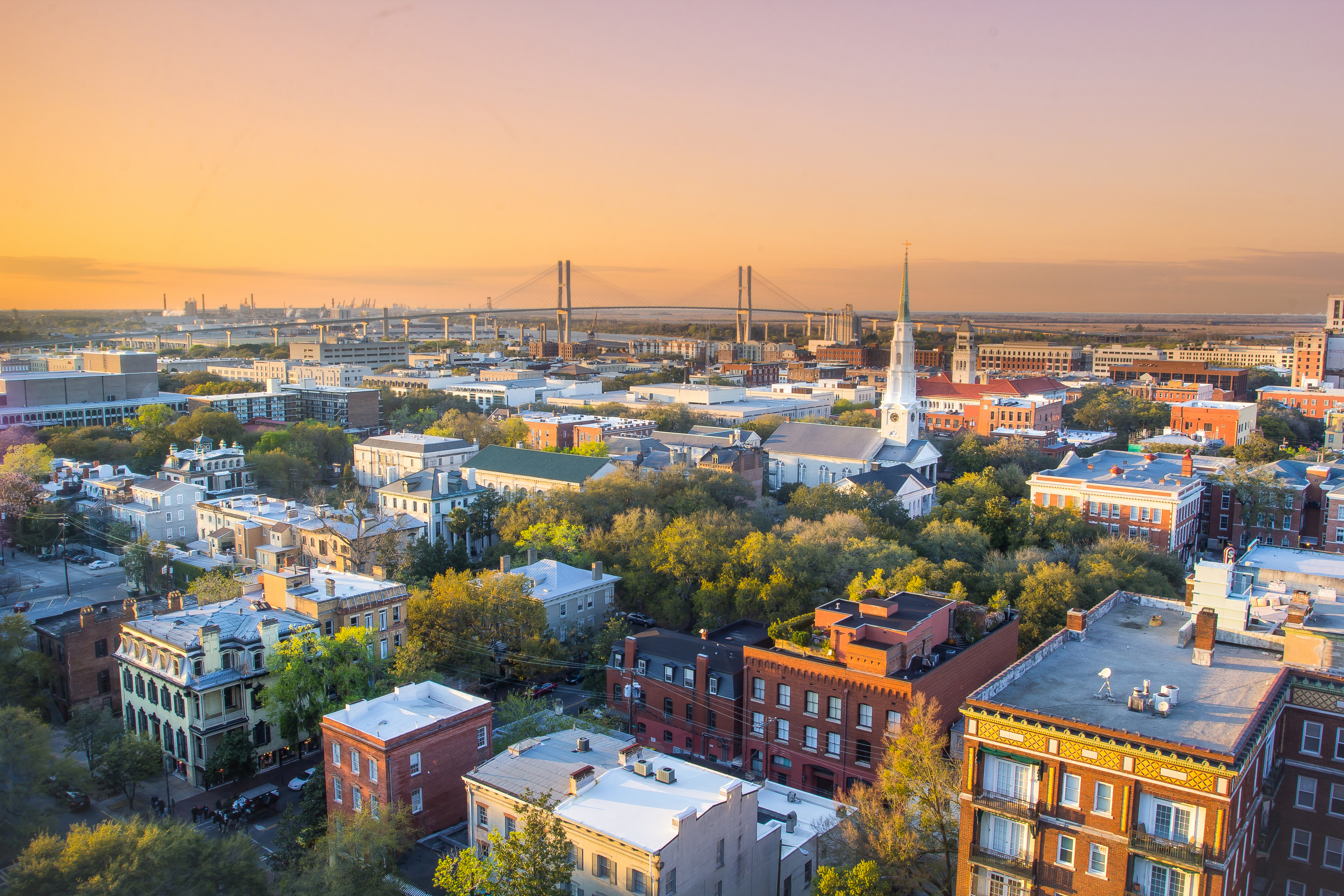 Savannah skyline at dusk with buildings and structures illuminated by colorful sunset. Savannah skyline at dusk with buildings and structures illuminated by colorful sunset.